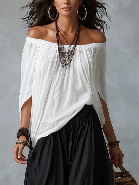 Completo con top bianco a spalle scoperte e pantaloni a zampa stile lanterna