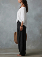 Completo con top bianco a spalle scoperte e pantaloni a zampa stile lanterna